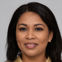 Joyful latino young-adult female with long  brown hair and brown eyes