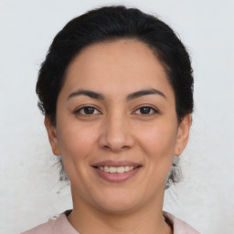 Joyful latino young-adult female with medium  brown hair and brown eyes