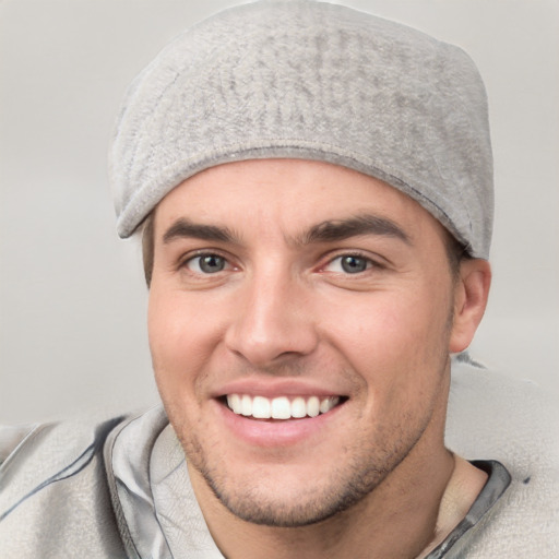 Joyful white young-adult male with short  brown hair and blue eyes