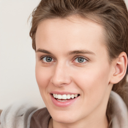 Joyful white young-adult female with long  brown hair and grey eyes