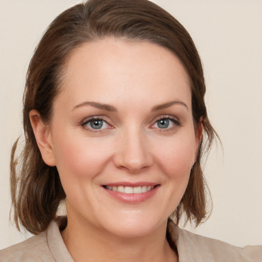 Joyful white young-adult female with medium  brown hair and blue eyes