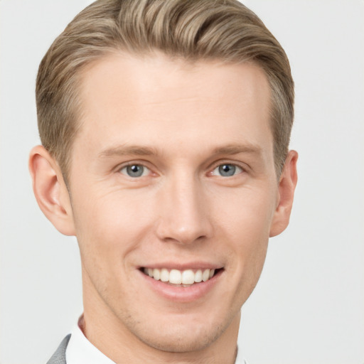 Joyful white young-adult male with short  brown hair and grey eyes