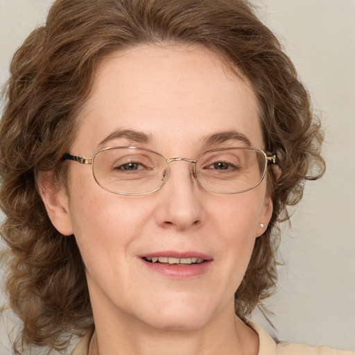 Joyful white adult female with medium  brown hair and blue eyes