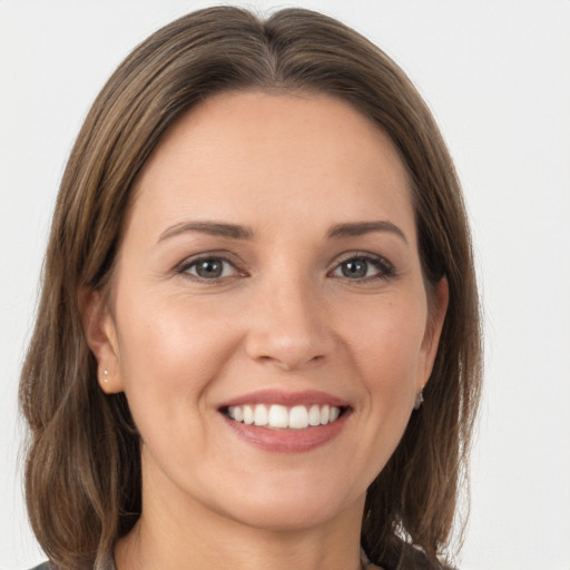 Joyful white young-adult female with long  brown hair and grey eyes