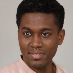 Joyful black young-adult male with short  brown hair and brown eyes