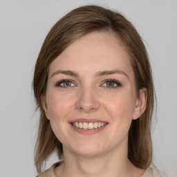 Joyful white young-adult female with medium  brown hair and grey eyes