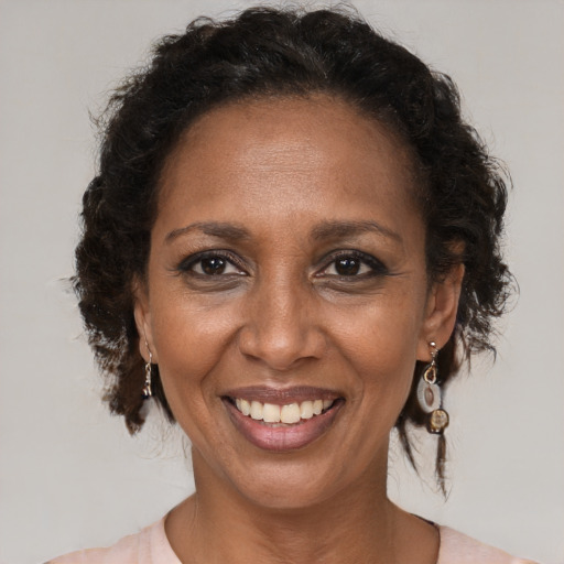 Joyful black adult female with medium  brown hair and brown eyes