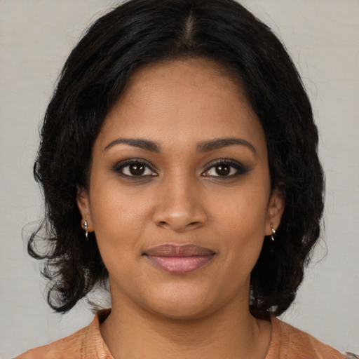 Joyful black young-adult female with medium  brown hair and brown eyes