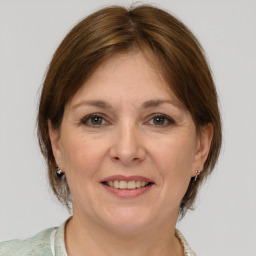 Joyful white adult female with medium  brown hair and grey eyes