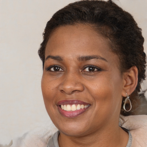 Joyful black young-adult female with short  brown hair and brown eyes