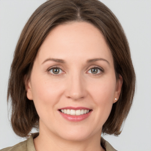 Joyful white young-adult female with medium  brown hair and grey eyes