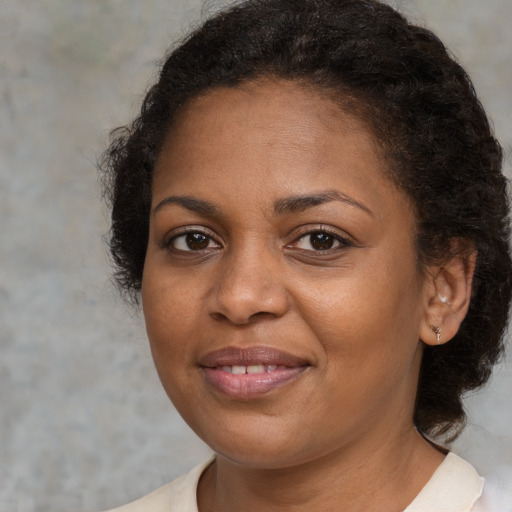 Joyful black adult female with medium  brown hair and brown eyes