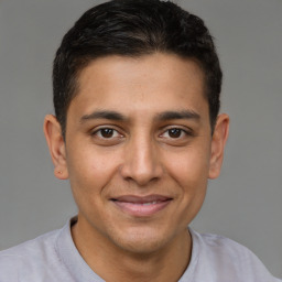 Joyful latino young-adult male with short  brown hair and brown eyes