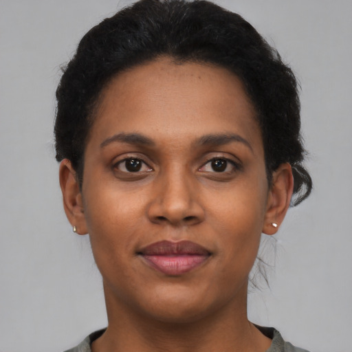 Joyful black young-adult female with short  brown hair and brown eyes