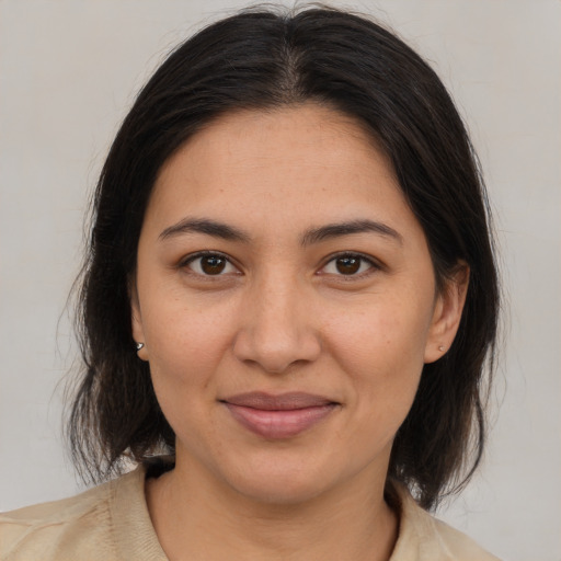 Joyful latino young-adult female with medium  brown hair and brown eyes