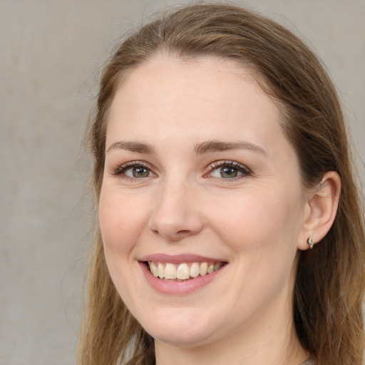 Joyful white young-adult female with long  brown hair and grey eyes