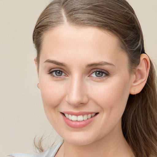 Joyful white young-adult female with medium  brown hair and grey eyes