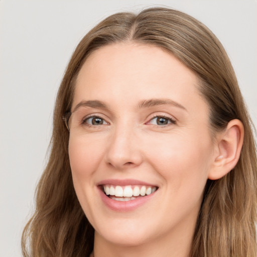 Joyful white young-adult female with long  brown hair and blue eyes