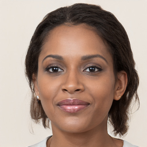 Joyful black young-adult female with medium  brown hair and brown eyes