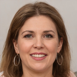 Joyful white adult female with medium  brown hair and grey eyes