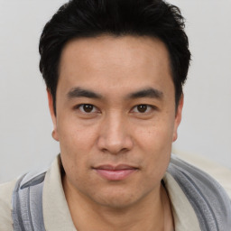 Joyful asian young-adult male with short  black hair and brown eyes