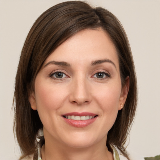 Joyful white young-adult female with medium  brown hair and grey eyes