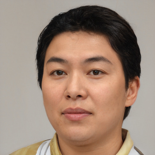 Joyful asian young-adult male with short  black hair and brown eyes