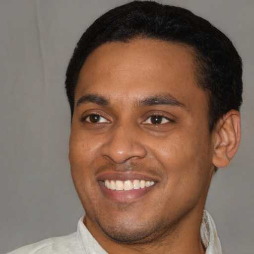 Joyful latino young-adult male with short  black hair and brown eyes