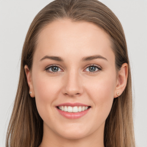 Joyful white young-adult female with long  brown hair and grey eyes