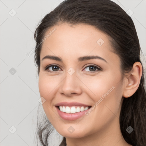 Joyful white young-adult female with long  brown hair and brown eyes