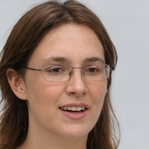 Joyful white adult female with long  brown hair and grey eyes