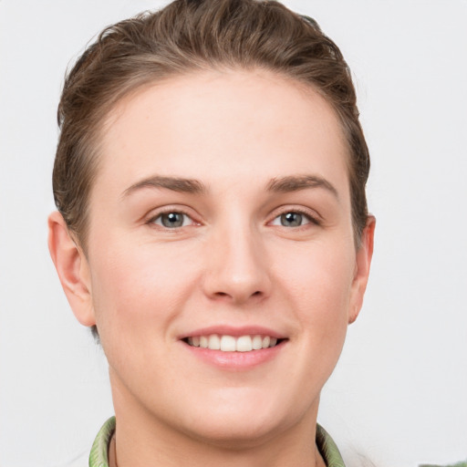 Joyful white young-adult female with short  brown hair and grey eyes