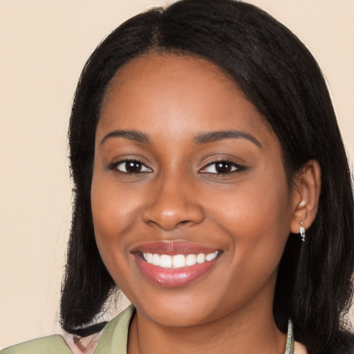 Joyful black young-adult female with long  black hair and brown eyes