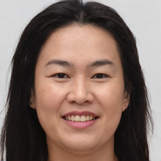 Joyful asian young-adult female with long  brown hair and brown eyes