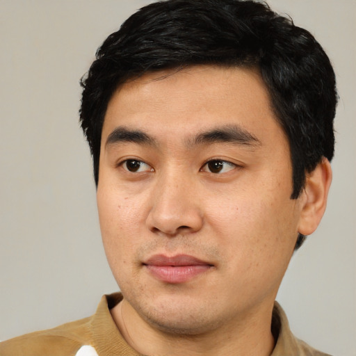 Joyful asian young-adult male with short  black hair and brown eyes