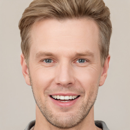 Joyful white adult male with short  brown hair and grey eyes