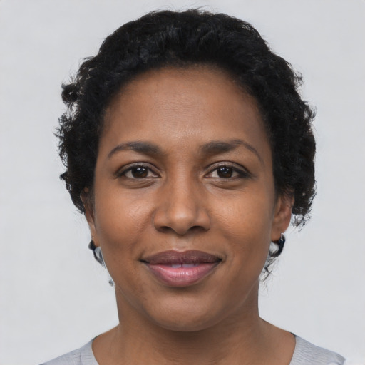Joyful black young-adult female with short  black hair and brown eyes