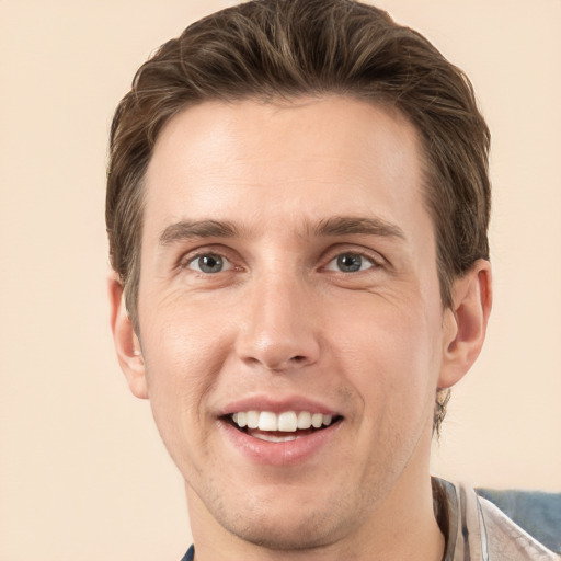 Joyful white young-adult male with short  brown hair and grey eyes