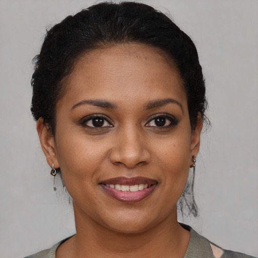 Joyful black young-adult female with medium  brown hair and brown eyes