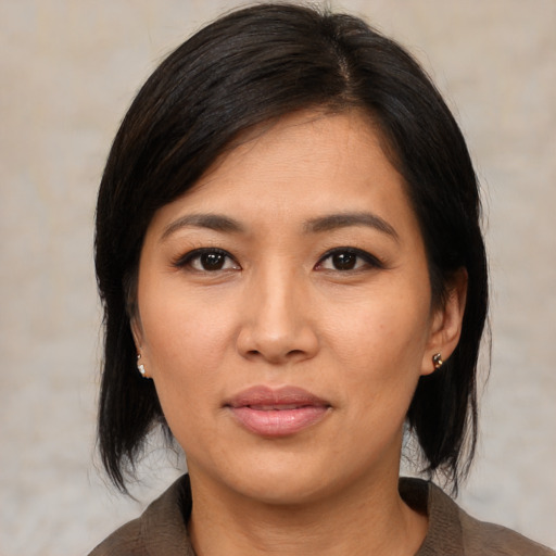 Joyful asian young-adult female with medium  black hair and brown eyes