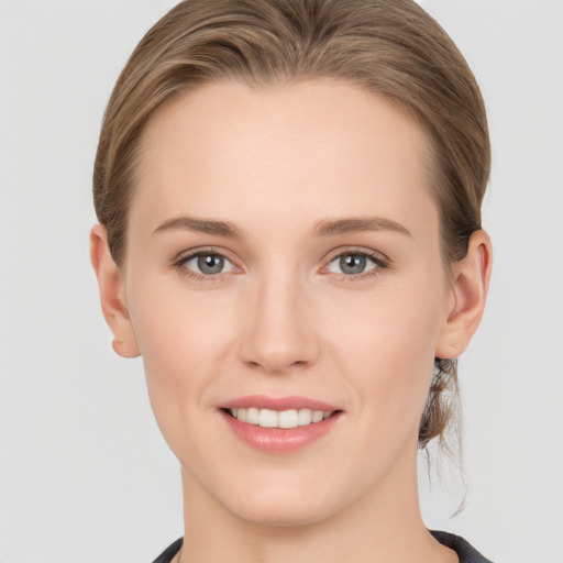 Joyful white young-adult female with medium  brown hair and grey eyes