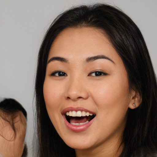 Joyful asian young-adult female with long  brown hair and brown eyes