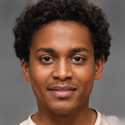 Joyful black young-adult male with short  brown hair and brown eyes