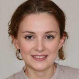 Joyful white young-adult female with medium  brown hair and blue eyes