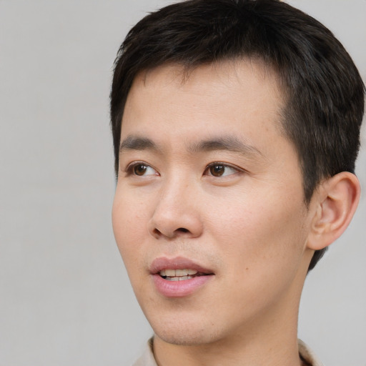 Joyful white young-adult male with short  black hair and brown eyes