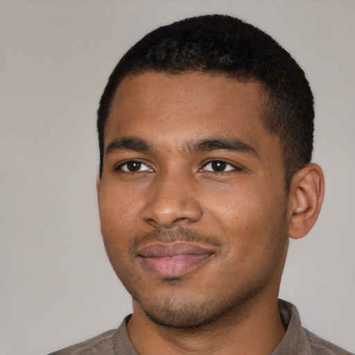 Joyful black young-adult male with short  black hair and brown eyes
