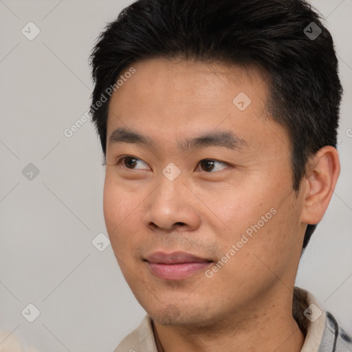 Joyful asian young-adult male with short  brown hair and brown eyes