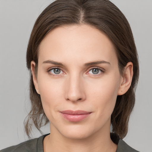 Joyful white young-adult female with medium  brown hair and grey eyes