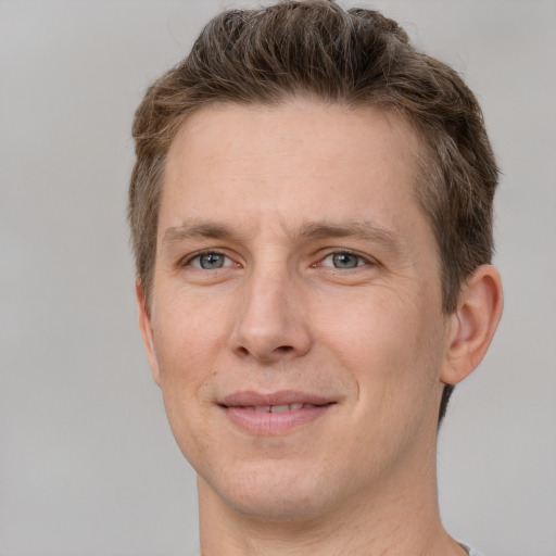 Joyful white adult male with short  brown hair and grey eyes