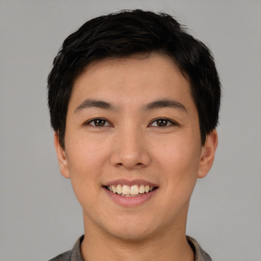 Joyful asian young-adult male with short  black hair and brown eyes
